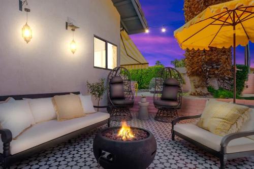 a patio with a couch and a fire pit at Moroccan Desert Oasis -Salt Pool - Spa - Games in Bermuda Dunes