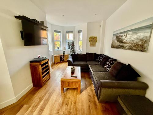 a living room with a couch and a table at Holiday Home Hot Tub & Sauna in Bournemouth