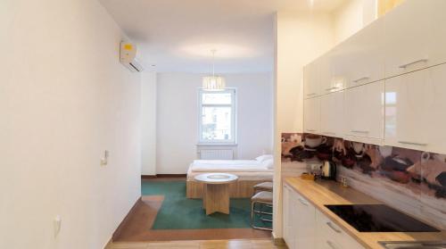 a white room with a bed and a table at Apartamenty Grodowa 2 in Gliwice