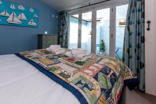 ein Schlafzimmer mit einem Bett mit einer Bettdecke darauf in der Unterkunft Waterfront Cottage in Aldeburgh