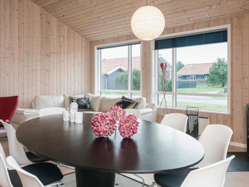 a dining room with a table with flowers on it at 4 star holiday home in Ulfborg in Fjand Gårde
