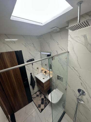 a bathroom with a sink and a glass shower at Appartement lumineux, tout confort à deux pas de la plage de Mehdia in Plage de Mehdia
