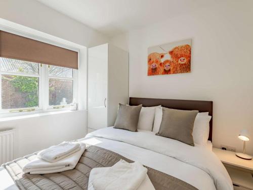 a white bedroom with a large bed and a window at 2 Bed in Louth oc-86797 in Louth