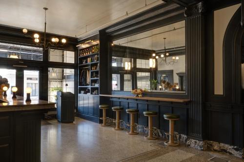 a restaurant with a bar with stools in a room at MarQueen Hotel - NEWLY RENOVATED in Seattle