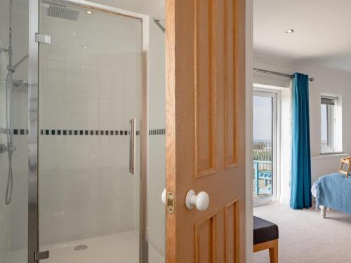 a bathroom with a shower with a glass door at 4 Bed in Cromer oc-81469 in West Runton