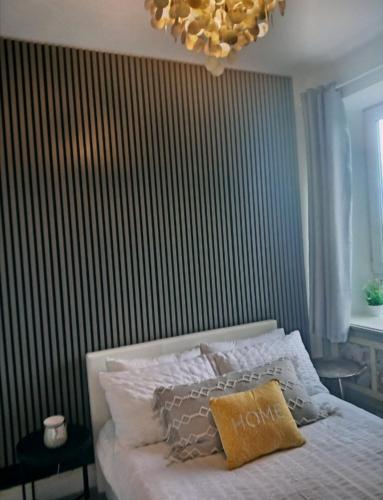 a bedroom with a bed with a striped wall at Cosy Seaside Snug in Helensburgh
