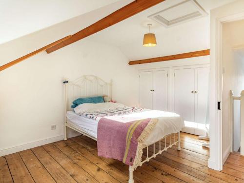 a bedroom with a white bed with a wooden floor at 3 Bed in Holt oc-87147 in Holt