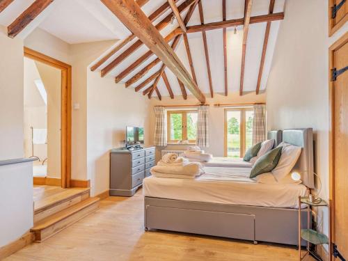 a bedroom with a large bed in a room with wooden ceilings at 5 Bed in Ashford oc-76428 in Smarden