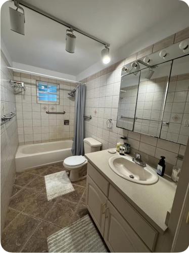 a bathroom with a sink and a toilet and a tub at The Palms apt 1 in Cedar Grove