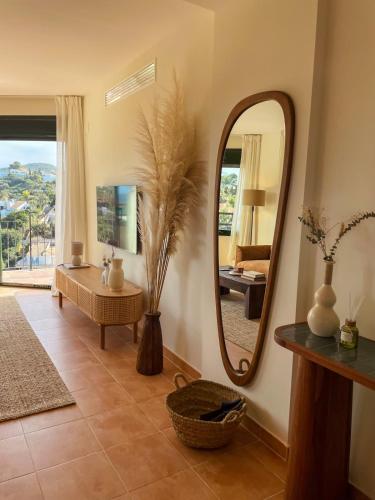 a living room with a mirror and a table at Seren Casa Begur - Illa Roja Beach in Begur