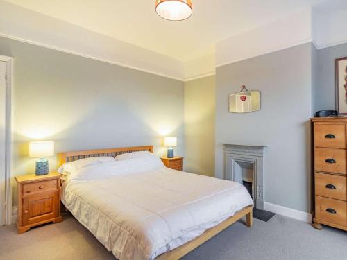 a bedroom with a bed and two night stands and a fireplace at 4 Bed in Holt oc-87148 in Holt