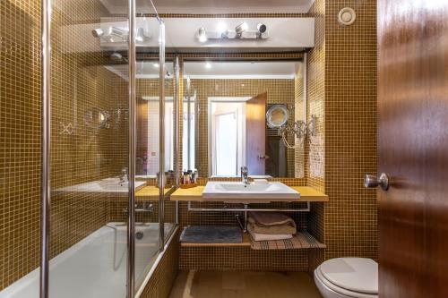 a bathroom with a tub and a sink and a toilet at Lisbon at Home in Lisbon