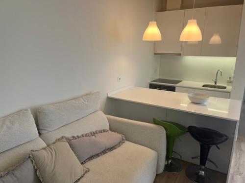 a living room with a couch and a kitchen at Casa do Cuco in Esposende