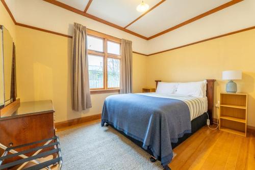 a bedroom with a bed and a dresser and a window at Kurow Escapes - Holiday Home in Kurow