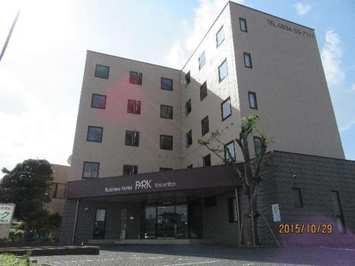 a large building with a parking lot in front of it at パーク琴芝 in Ube
