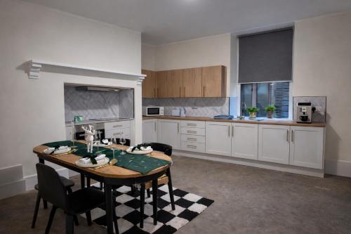 a kitchen with a table and chairs in a room at Saféra Dewsbury Westpark in Batley Carr