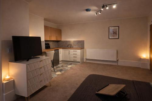 an empty kitchen with a tv on a cabinet at Saféra Dewsbury Westpark in Batley Carr