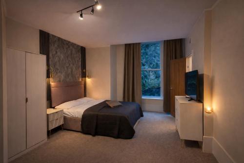 a hotel room with a bed and a television at Saféra Dewsbury Westpark in Batley Carr