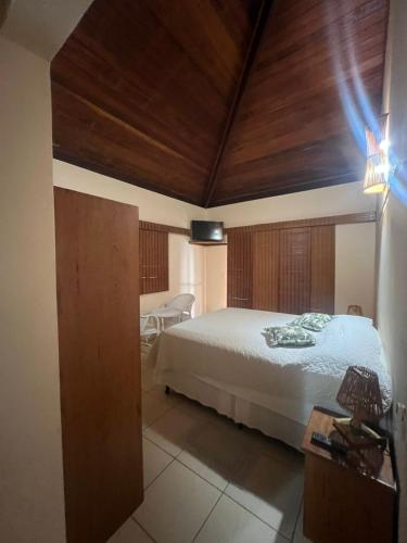 a bedroom with a bed with a wooden ceiling at Apoena in Conde