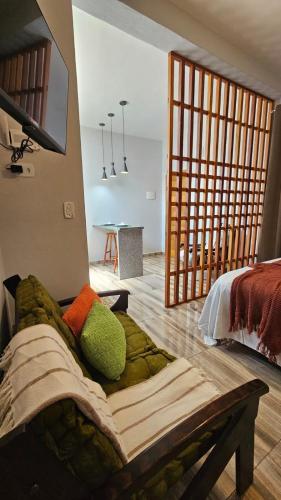 a living room with a couch in front of a bedroom at Kitinet Cunha in Cunha