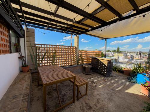 a patio with a wooden table and a fence at Casa Céntrica con Roof garden y Vistas a la Ciudad in Guadalajara
