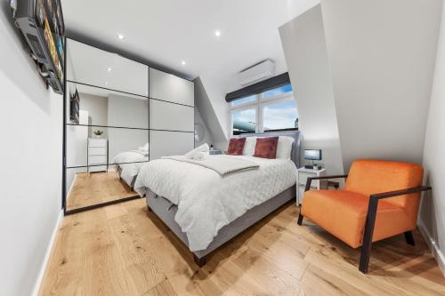 a bedroom with a bed and an orange chair at Luxury 2 bed C1 apartment London Bridge in London