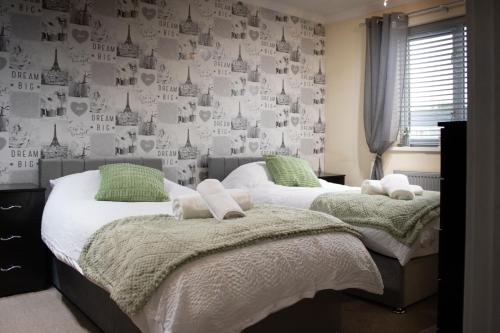 two twin beds in a bedroom with a wallpaper at 6 Bed home near to Birmingham Nec Airport 6 miles from city centre in Marston Green