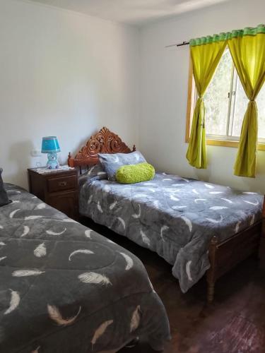 a bedroom with two beds and a window at Cabañas Doña Magali in Bucalemu
