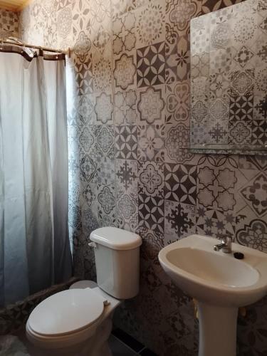 a bathroom with a toilet and a sink at Cabañas Doña Magali in Bucalemu