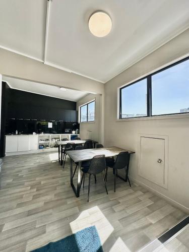 a kitchen and dining room with tables and chairs at SpinCity Lodge Auckland in Auckland