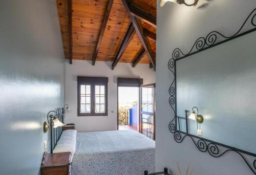 a bedroom with a bed and a mirror on the wall at Complejo rural Alhelí - Apartamentos y habitaciones in Valdredo