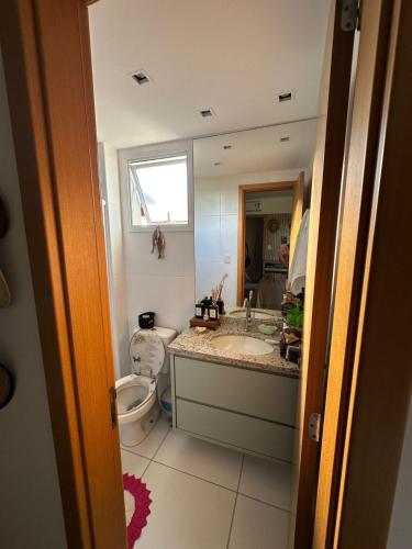 a bathroom with a sink and a toilet and a mirror at Apartamento Garden in Baixio