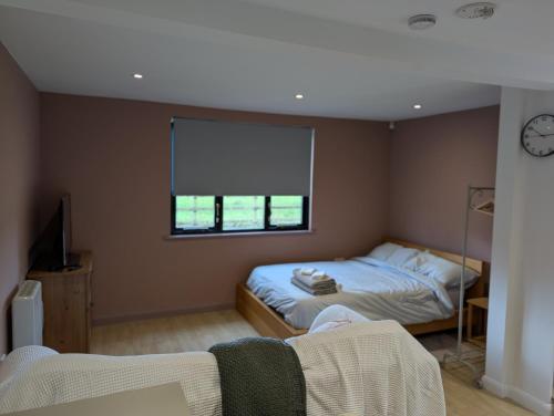 a bedroom with two beds and a window at Studio Apartment - Iver Heath in Uxbridge