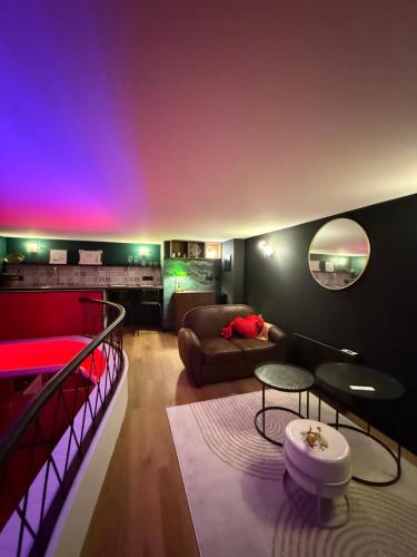 a living room with a couch and a table at Le 1920- Spa & Sauna privé- Love Room in Le Havre