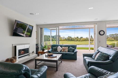 a living room with two couches and a fireplace at Clearwater Golf Resort - Entire Luxury Home in Christchurch