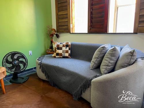 a couch in a living room with a fan at BECA Residencial in Canoa Quebrada