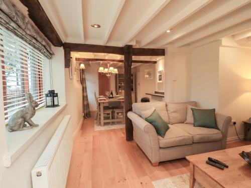 a living room with a couch and a table at Jasmine Cottage in Keswick