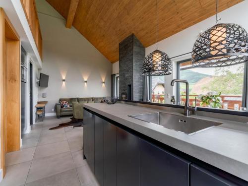 a kitchen with a sink and a living room at Alpinn Wellness 2 in Sankt Margarethen im Lungau