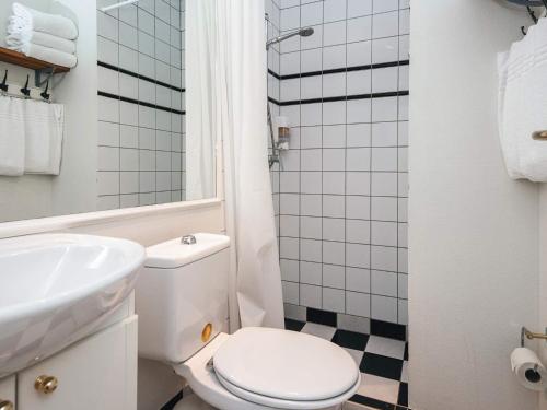 a white bathroom with a toilet and a sink at Spacious holiday home with garden in Skanderborg