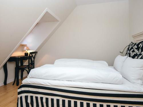 a bedroom with a bed and a desk in a attic at Spacious holiday home with garden in Skanderborg