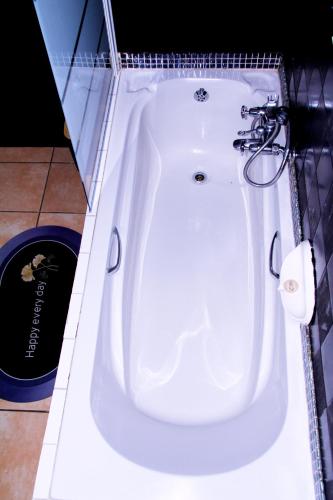 a white bath tub in a bathroom with a black wall at Wakanda in Johannesburg