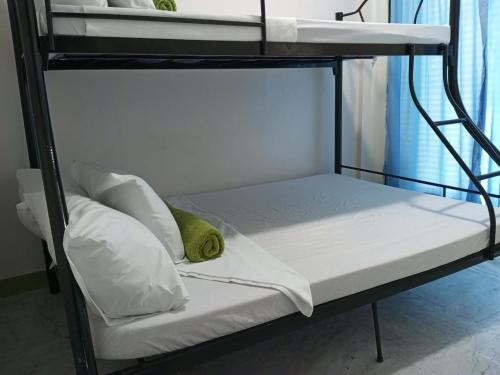 a bunk bed with white sheets and pillows on it at Liberty's Homestay Private Apartment in Coron