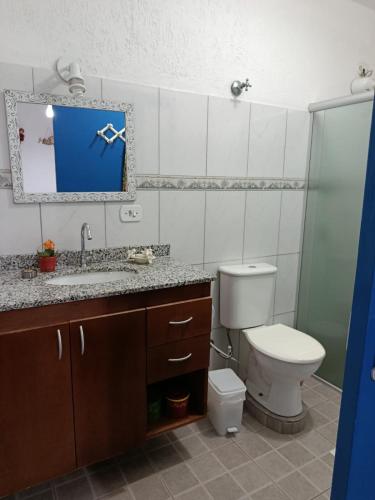 a bathroom with a toilet and a sink and a mirror at Refúgio Sereno São Seba in São Sebastião