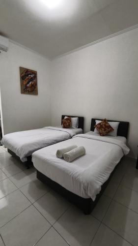 two beds sitting next to each other in a room at Saphala Suites Secondfloor in Seminyak