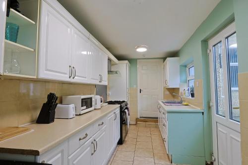 a kitchen with white cabinets and a microwave at Elevate suites Darlington in Darlington