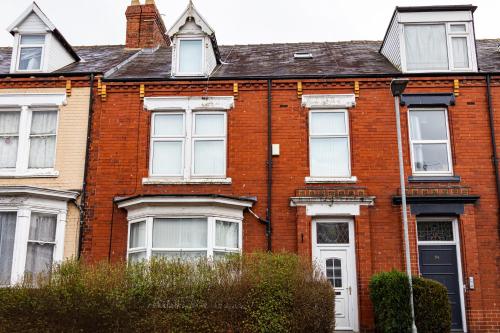 a red brick house with white windows and a black door at Elevate suites Darlington in Darlington