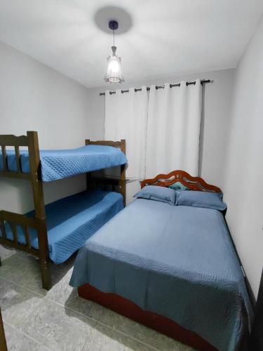 a bedroom with two bunk beds and a lamp at Chácara Rancho Imperial - Socorro - SP - Piscina, Churrasqueira, Forno à Lenha, Campo de Futebol e uma linda Vista para a Montanha! in Socorro