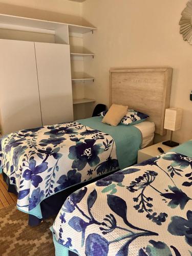 a bedroom with two beds with blue and white covers at Apartamento con alberca cerca de la playa in Manzanillo