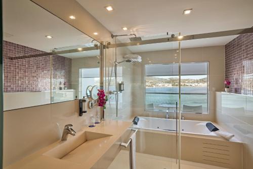 a bathroom with a tub and a large mirror at Hotel Argos Ibiza in Talamanca