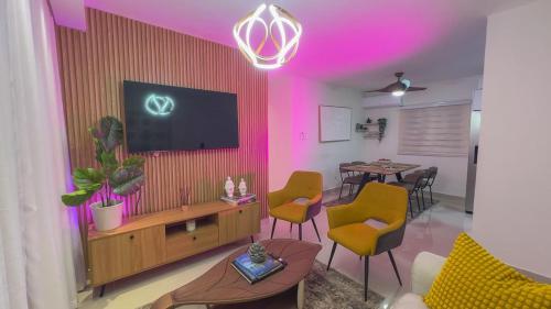 a living room with a tv and a table with chairs at San Isidro Urban suite in Juan López
